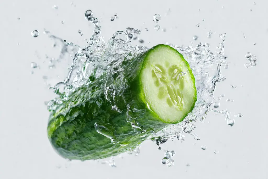 A cucumber sliced open to reveal splashing water illustrating are cucumbers good for weight loss