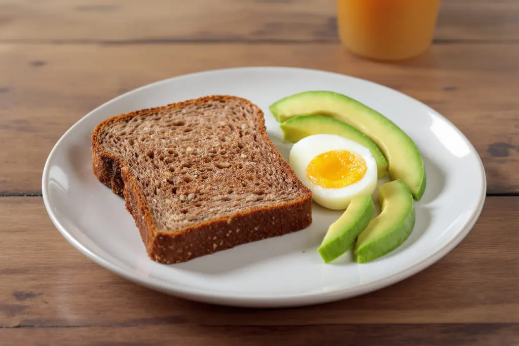 a balanced breakfast plate with a single slice of rye bread an egg and avocado showing a satisfying high-fiber meal for weight loss